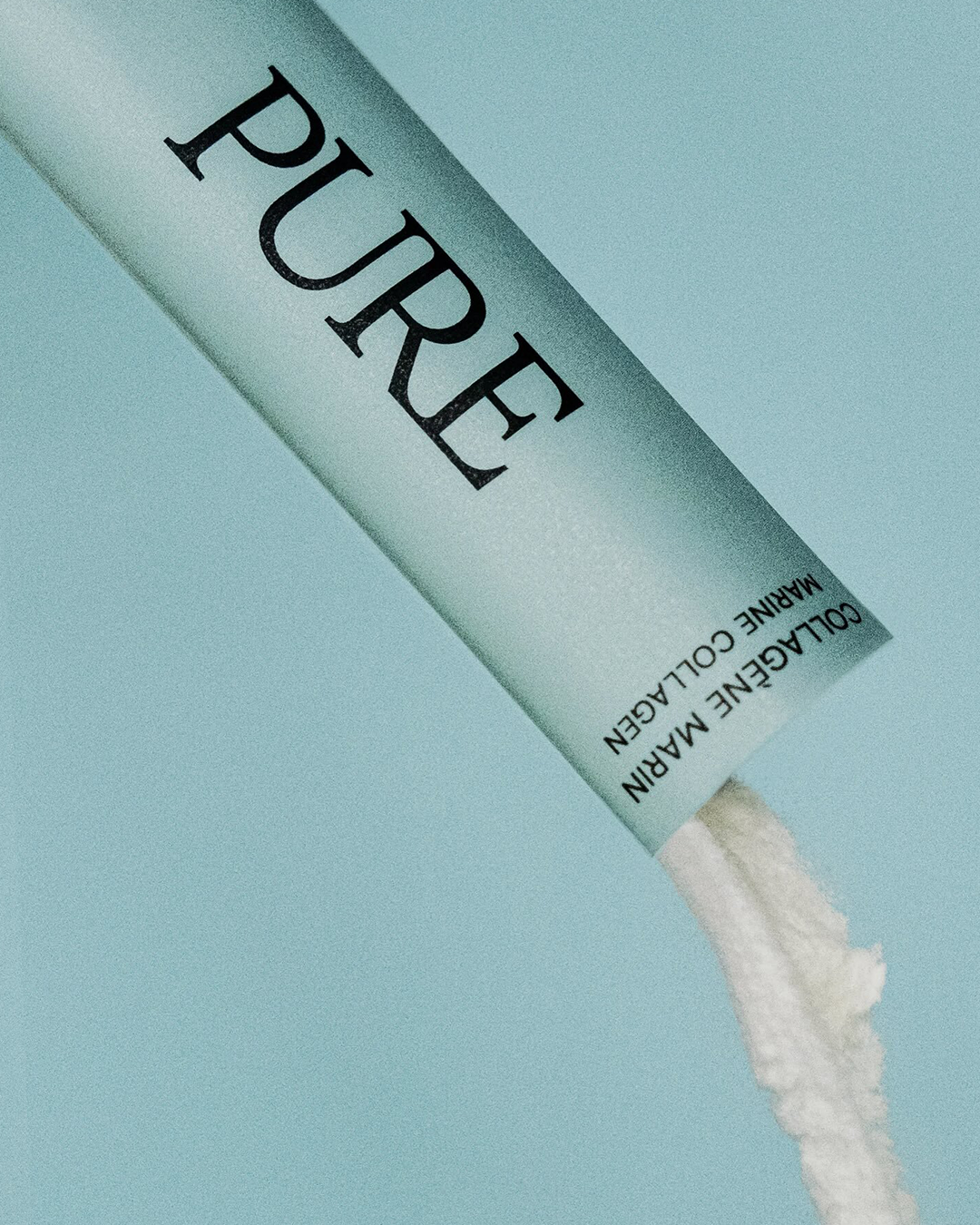 sachet de collagène marin pure mcs en gros plan avec poudre blanche versée sur fond bleu